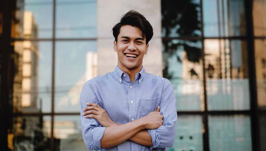 Happy Young Businessman Standing with a Big Smile in the City. C